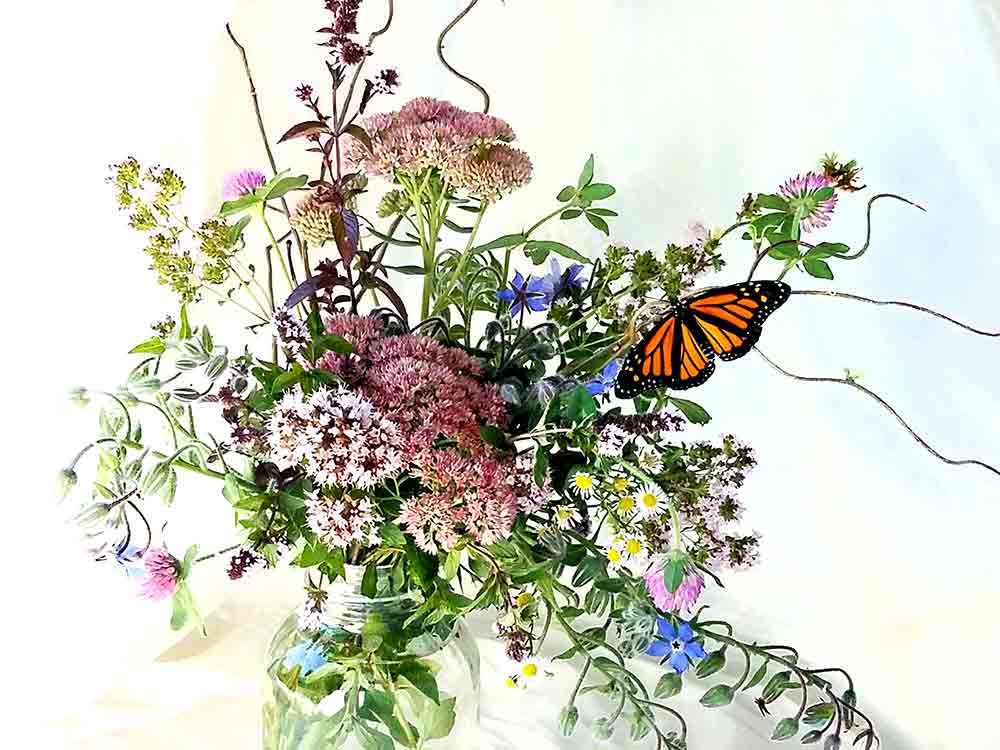 Female Monarch butterfly on bouquet of wild flowers. 