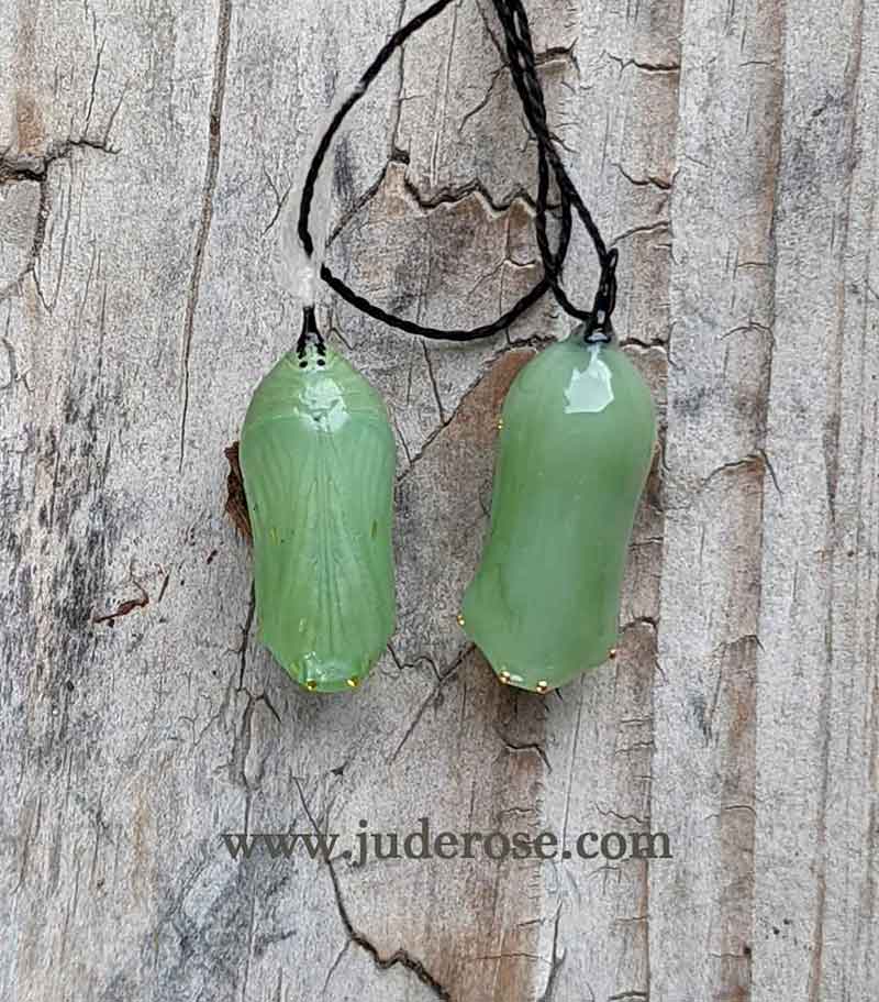 actual Monarch chrysalis next to a Jude Rose replica of Monarch chrysalis in glass and 24k gold